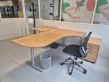 a desk with a chair and a trash can in front of it