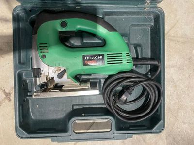 un outil électrique vert et noir dans un étui en plastique