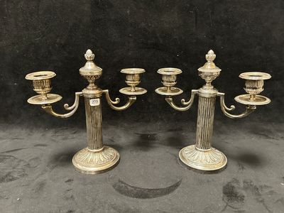 un ensemble de quatre chandeliers anciens en laiton avec des bougies