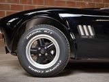 a black sports car parked in front of a brick wall