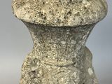 an old stone vase sitting on top of a white table