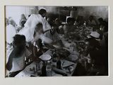 photographie en noir et blanc d'un groupe de personnes assises autour d'une table
