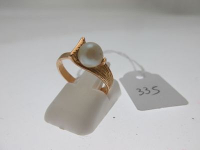 une bague ornée d'une perle et d'une étiquette de prix