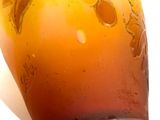 a glass vase that has a yellow and brown design on it