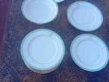 six assiettes blanches à bord bleu sont posées sur une table