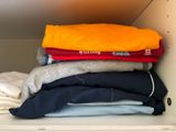 a lot of clothes that are stacked on top of each other