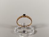a close up of a gold ring with a black stone on it