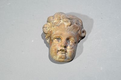 une statue représentant la tête d'un homme, fixée au mur