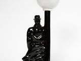 a lamp that has a statue on it next to a lamp