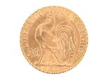 a gold coin with a rooster on it on a white surface