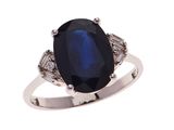 gros plan d'une bague avec une pierre bleue et des diamants