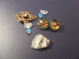 une pierre, un collier et une paire de boucles d'oreilles posés sur une table