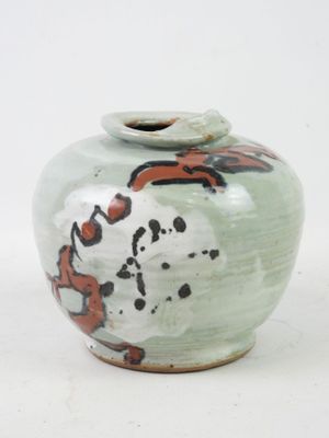 a green vase with a red and black design on it