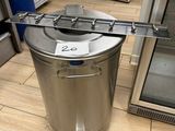 a metal trash can sitting on the floor next to a refrigerator