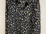 a black shirt with a leopard print on it hanging on a hanger
