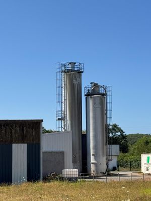 un grand bâtiment avec deux grands silos en arrière-plan