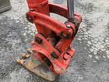 a red excavator that is sitting on the ground