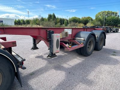 une remorque à plateau rouge garée sur un parking