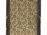 an old photo of a picture frame with a pattern of leaves on it