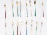 un service de douze fourchettes en or et en argent aux manches de différentes couleurs