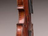 an old violin with a bow hanging from it ' s back