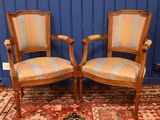 une paire de chaises en bois avec des assises rembourrées, dans une pièce bleue
