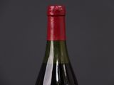 the bottle of wine is sitting on the table with a black background