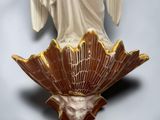 statue of an angel on a shell with wings on a white background