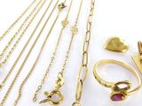 un gros plan sur un ensemble de bijoux en or posés sur une surface blanche