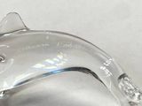 a silver dolphin figurine sitting on a white surface
