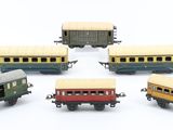 five toy trains that are lined up on a white surface