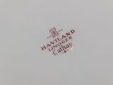 a close up of a white plate with a red logo on it