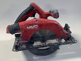 une photo d'une scie circulaire rouge posée sur une surface blanche