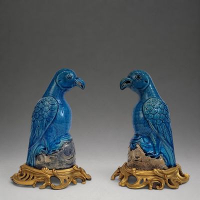 une paire de perroquets bleus posés sur un socle doré