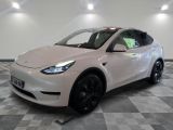 Le SUV Tesla blanc est garé sur un sol à damier.