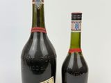 two bottles of wine sitting next to each other on a white surface