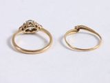 two gold rings with diamonds on them sitting next to each other