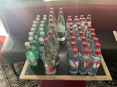 plusieurs bouteilles d'eau posées sur un plateau, sur une table