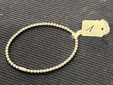 un bracelet muni d'une étiquette, posé sur une table