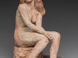 an image of a statue of a woman sitting on a rock