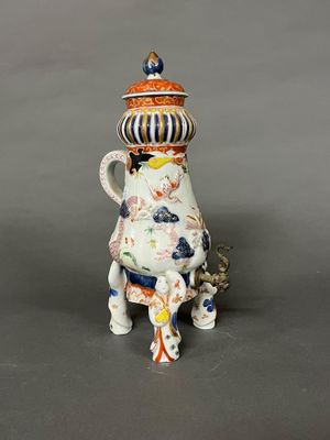 une théière en porcelaine avec un couvercle, posée sur un socle