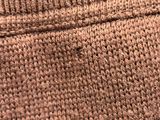 a close up of a brown knitted sweater with buttons