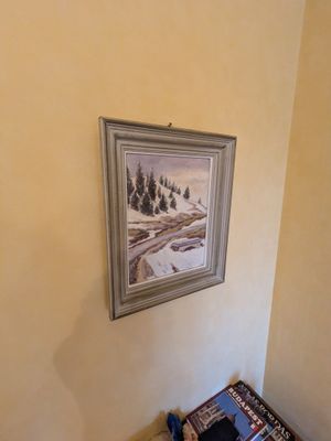 une photo d'un tableau accroché au mur au-dessus d'un lit