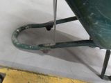 a wheelbarrow that is sitting on the floor next to a measuring tape