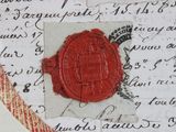 a red wax seal sitting on top of a piece of paper