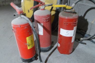 several fire extinguisors are lined up in a row next to each other