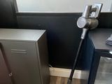 a vacuum that is sitting on the floor next to a cabinet