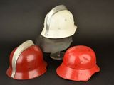 three red and white helmets sitting next to each other on a black surface
