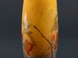 yellow vase with orange flowers on it against a dark background