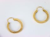 deux paires de boucles d'oreilles en or sur fond blanc